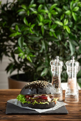 blackburger black mamba with marbled beef on a gray stone background on a wooden table