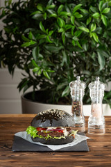 blackburger black mamba with marbled beef on a gray stone background on a wooden table