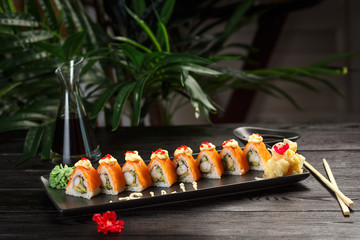 set of fuji rolls on a rectangular black plate on a black wooden background