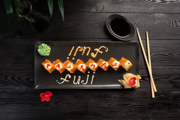 set of fuji rolls on a rectangular black plate on a black wooden background