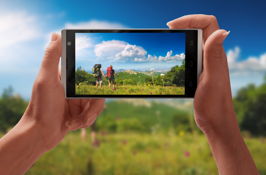 Couple of hikers on a screen of smartphone