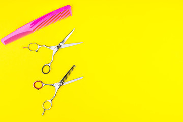 Stylish Professional Barber Scissors and comb on yellow background. Hairdresser salon concept, Hairdressing Set. Haircut accessories. Copy space image, flat lay.