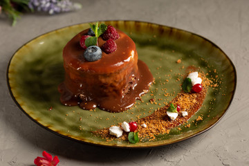 pancake with melted chocolate and berries on a green plate