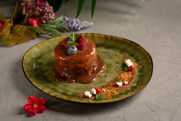 pancake with melted chocolate and berries on a green plate