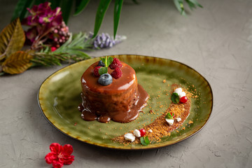 pancake with melted chocolate and berries on a green plate