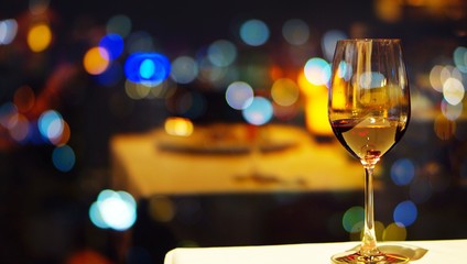 A glass of wine in a restaurant or dinning room with bokeh background,romantic scene for valentine dating or celebrate special day, 