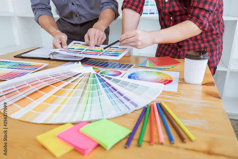 Aufkleber teamwork of young creative designers working on project together and choose color swatch samples for