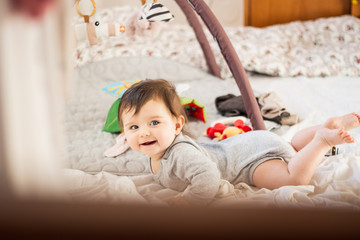 Fototapeta premium happy baby smiling while playing in bed
