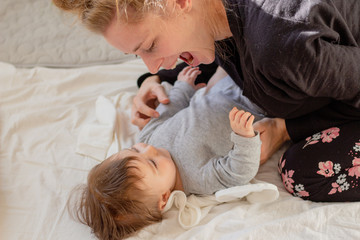 mother tickling her baby while playing