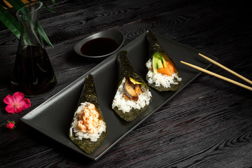 Temaki mix with salmon, eel and shrimp on a dark wooden background