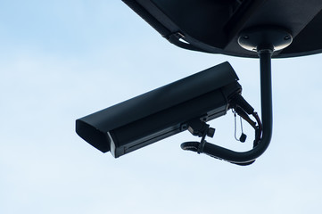 Silhouette of black security camera of security on blue sky background