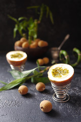 Some lychees, passion fruit and bamboo on dark background. Asian style