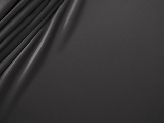 Smooth elegant dark grey / black silk or satin luxury cloth fabric texture, abstract background design.