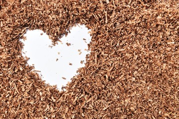heart-shaped and wood saw dust on dirty white background