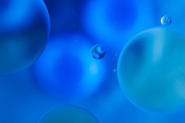 oily drops  in water with colorful background, close-up