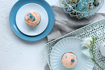 Tasty Easter cupcakes on white table