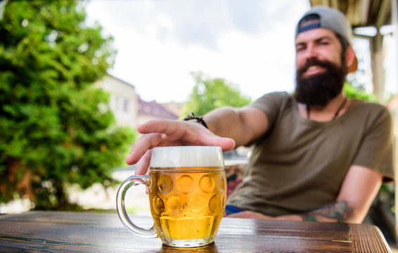 Enjoying non alcoholic beer. Bearded man grabbing alcoholic drink in bar. Hipster sitting with alcoholic beverage in pub. He is a social drinker not an alcoholic