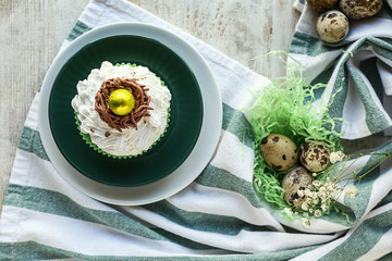 Tasty Easter cupcake with eggs on table