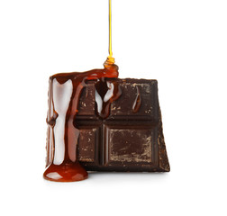 Liquid caramel pouring on chocolate against white background