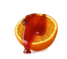 Orange covered with liquid caramel on white background