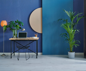 close up working table and vase of plant style in the room, dark blue stone wall and brown detail.