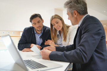 Couple signing contract with real estate agent