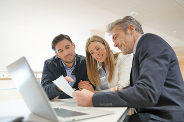 Couple signing contract with real estate agent