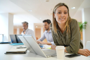 Female startup team member smiling at camera in office