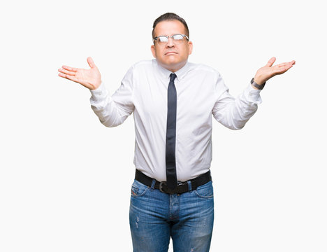 Middle age bussines arab man wearing glasses over isolated background clueless and confused expression with arms and hands raised. Doubt concept.