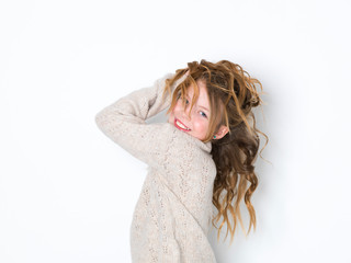 Naklejka premium pretty blonde girl with curly hair posing against a white background and is happy
