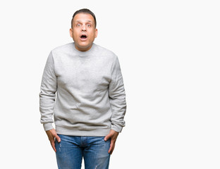 Fototapeta premium Middle age arab man wearing sport sweatshirt over isolated background afraid and shocked with surprise expression, fear and excited face.