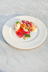 Apple strudel table raisins ice cream mint sultana berries sauce red green white plate close up top view