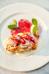 Apple strudel table raisins ice cream mint sultana berries sauce red green white plate close up top view