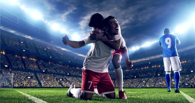 Professional footballer is happy and slides with his hands to the air. Another soccer player runs after him happily. Action takes place on soccer stadium.  Stadium and crowd are made in 3D.