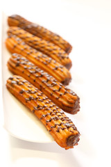 spanish chocolate fritters on a white dish with white background