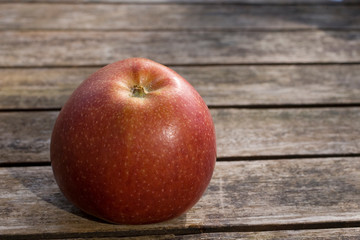 Roter Apfel liegt auf einem Holztisch