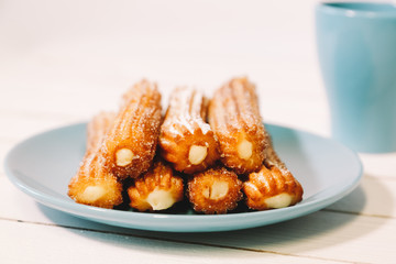 spanish sugar fritters served on blue dish on a wooden table