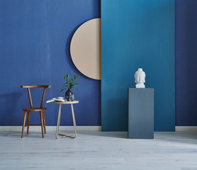 interior of a room with chair table and vase of plant. Blue stone wall background.