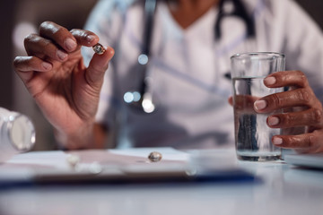 Close up African American nurse holding omega 3 capsule.