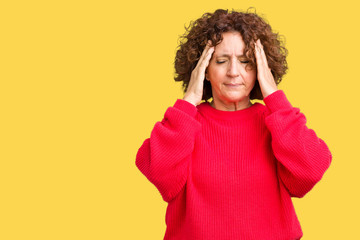 Fototapeta na wymiar Beautiful middle ager senior woman red winter sweater over isolated background with hand on head for pain in head because stress. Suffering migraine.