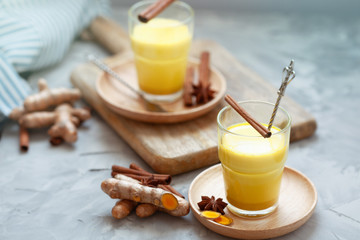 Golden tea with almond milk, turmeric, cinnamon, honey and ginger. Healthy detox morning beverage with spices on light backround close up - obrazy, fototapety, plakaty