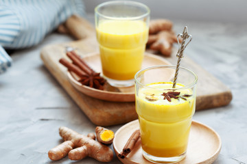 Golden tea with almond milk, turmeric, cinnamon, honey and ginger. Healthy detox morning beverage with spices on light backround close up