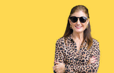 Middle age mature rich woman wearing sunglasses and leopard dress over isolated background happy face smiling with crossed arms looking at the camera. Positive person.