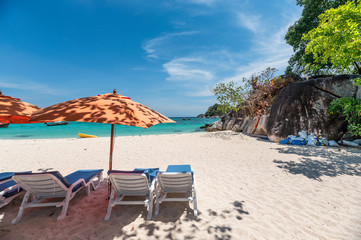 Umbrella with sunbed on the white beach in tropical sea