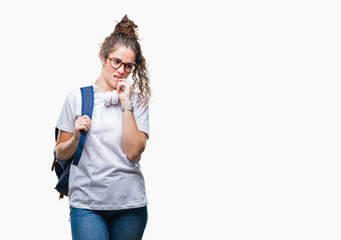 Young brunette student girl wearing backpack and headphones over isolated background looking stressed and nervous with hands on mouth biting nails. Anxiety problem.
