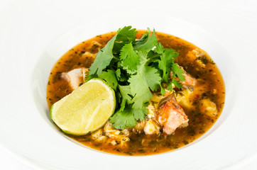 Crab with chili sauce, lime, parsley and rice on a plate on a white background