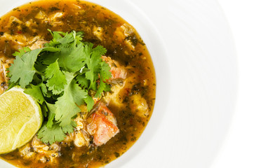 Crab with chili sauce, lime, parsley and rice on a plate on a white background