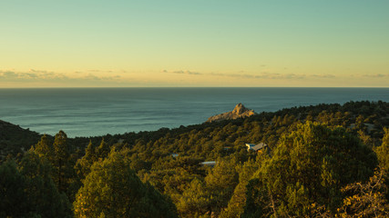 beautiful landscape of gorgeous nature, horizon between sea and blue sky during sunset, green trees, hills