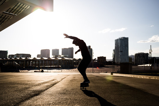 Man jumping and riding with a skateboard outdoors in a city
