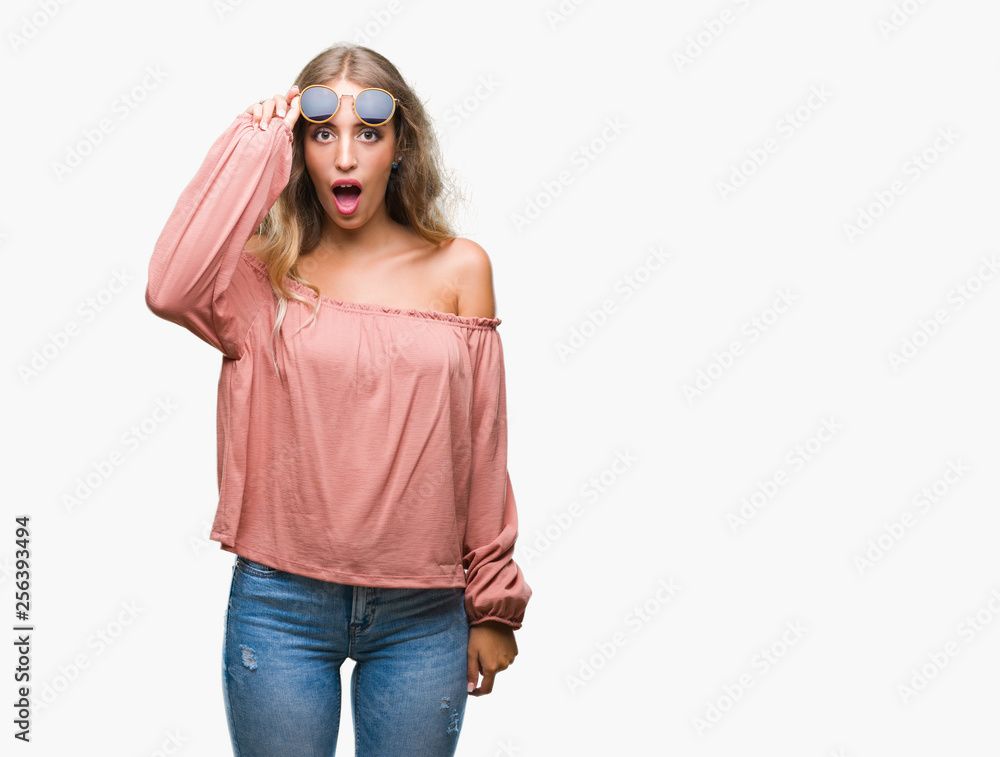 Sticker beautiful young blonde woman wearing retro sunglasses over isolated background afraid and shocked wi